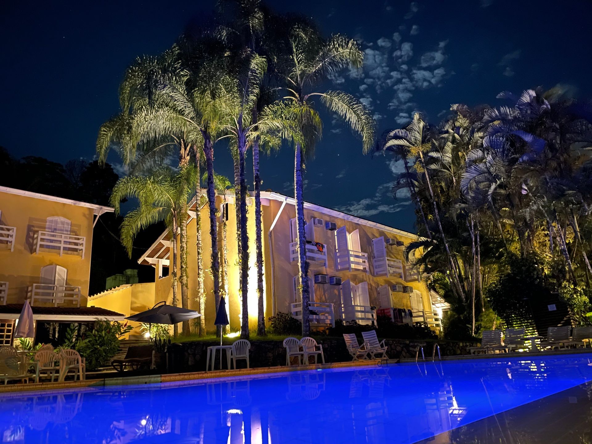 "vista noturna da piscina com luz azulada para o conforto dos clientes da Marina Porto Canoa"